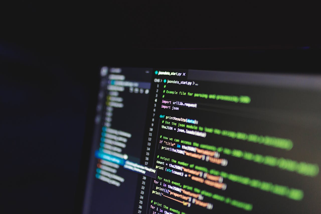 who-we-are Programming code on a computer screen in a dark room, showcasing technology and IT expertise.